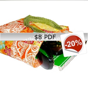 Peut inclure: Un sac fourre-tout en tissu coloré avec une bordure verte, rempli de lunettes de soleil, un carnet et un stylo. Le sac a un motif cachemire et est vendu 8 €. Un cercle rouge avec le texte -20% est dans le coin de l'image.