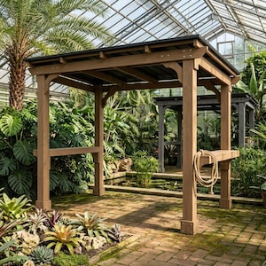 May include: A wooden pergola structure with a dark roof, featuring four vertical posts, horizontal support beams, and a built-in shelf on the side. A coiled tan rope hangs from the side of the structure, which is positioned on a brick patio.