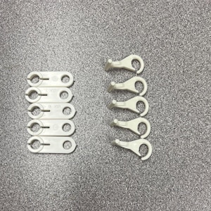 May include: Two sets of white plastic clips. One set has six clips with the text "2-VO17" on each clip. The other set has five clips with a hook on each clip.