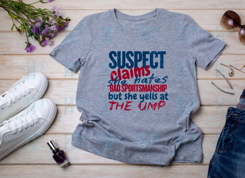 May include: Gray t-shirt with a blue and red graphic that says "SUSPECT claims she hates BAD SPORTSMANSHIP but she yells at THE UMP"