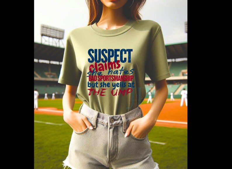 May include: A green t-shirt with the text "SUSPECT claims she hates BAD SPORTSMANSHIP but she yells at THE UMP" in blue, red, and white lettering.