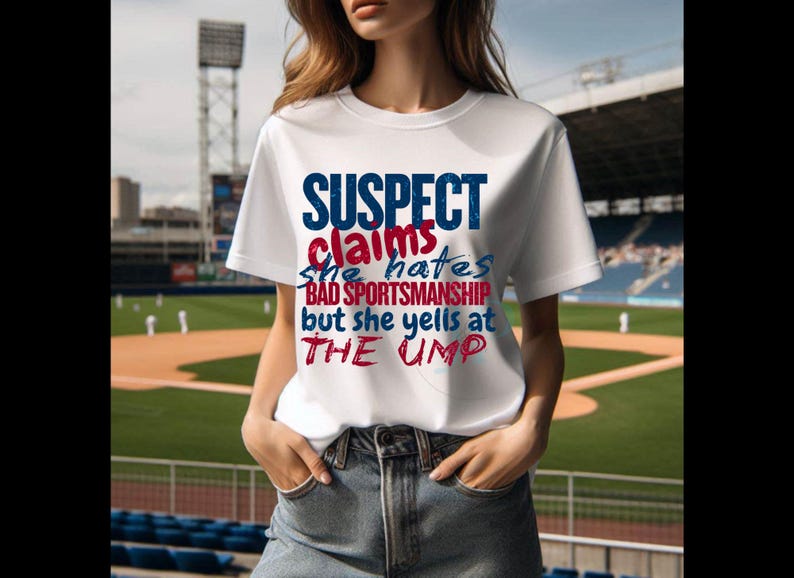 May include: White t-shirt with a blue and red graphic that says "SUSPECT claims she hates BAD SPORTSMANSHIP but she yells at THE UMP"