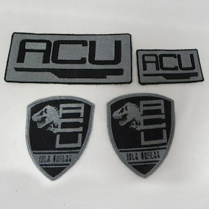 May include: Four embroidered patches, two black with a gray dinosaur and the text "ISLA NUBLAR", and two gray with the text "ACU" in black.