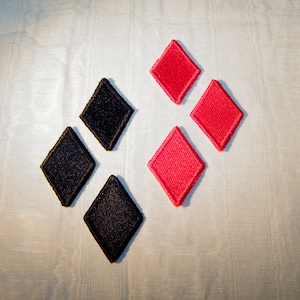 May include: A set of black and red diamond-shaped patches. The patches are arranged in a pattern, with the black patches on the left and the red patches on the right.