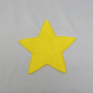 May include: A yellow felt star with five points. The star is on a white background.