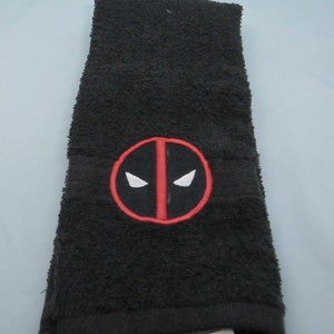 May include: Black hand towel with a red and white embroidered Deadpool logo.