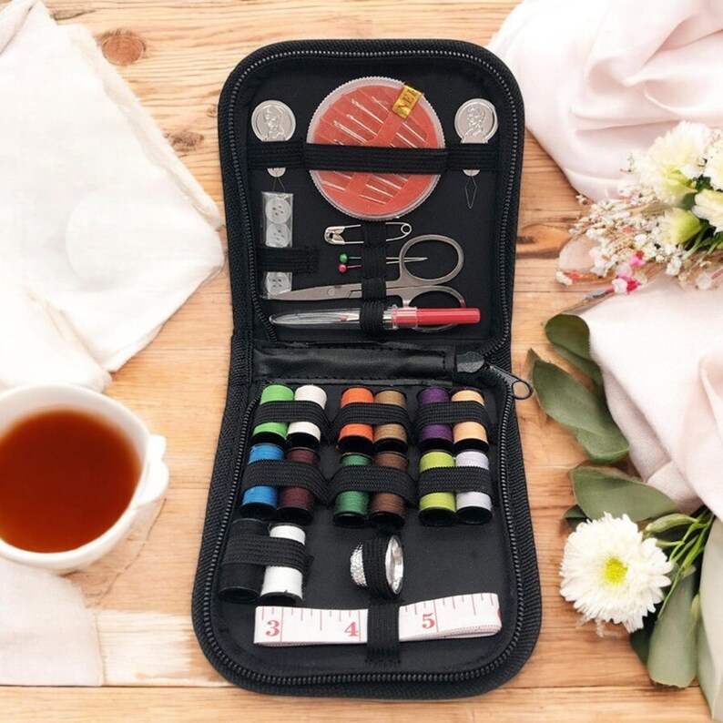 May include: A black zippered travel sewing kit with a variety of colored threads, needles, buttons, a thimble, and a measuring tape.