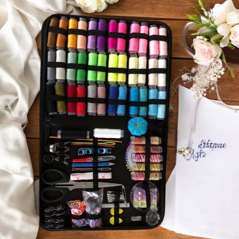 May include: A black sewing kit case with a variety of colorful threads, needles, pins, and other sewing supplies. The case is open and the supplies are visible. The case also has a label that says "Stitchaee Arts".