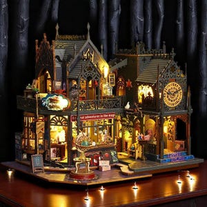 Puede incluir: Un modelo de madera detallado de un edificio de estilo gótico con una torre del reloj, múltiples ventanas y un letrero que dice "Real adventure in the magic". El modelo está iluminado con luces blancas cálidas y se encuentra sobre una superficie de madera oscura.