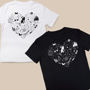 May include: Two t-shirts with a heart-shaped design featuring a variety of black and white illustrations. The design includes a guitar, a typewriter, a snake, a pair of sunglasses, a hat, and a pair of trees.