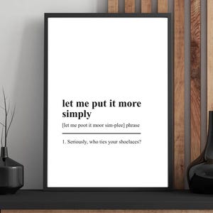 May include: A framed print with the text "let me put it more simply" in a black frame. The text includes a phonetic pronunciation and the question, "Seriously, who ties your shoelaces?"
