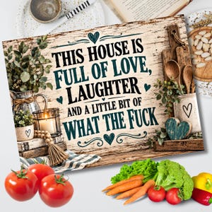 May include: A rectangular wooden sign with a distressed white finish featuring the black text: THIS HOUSE IS FULL OF LOVE, LAUGHTER AND A LITTLE BIT OF WHAT THE FUCK. The sign is decorated with black heart icons and flourishes, surrounded by fresh produce.
