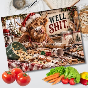 May include: A rectangular wall art print featuring a brown Highland cow wearing a red Santa hat and a patterned apron, baking cookies in a kitchen. The text WELL SHIT is printed in large red and black letters. Fresh tomatoes and vegetables are below.