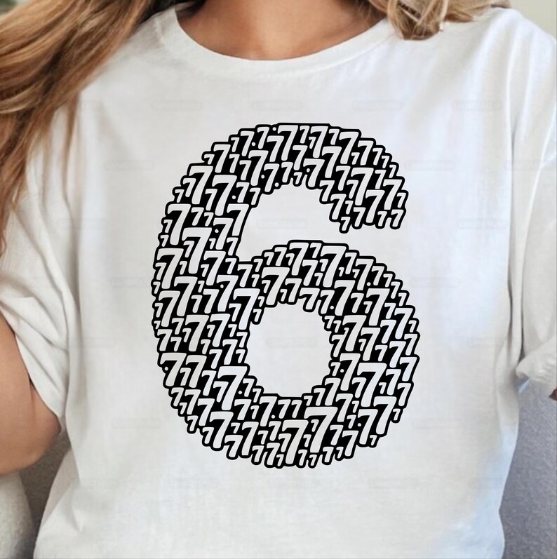May include: White t-shirt featuring a large number six, composed of numerous smaller sevens in black. The design is centered on the shirt, creating a bold graphic statement. The shirt is made of a soft material.