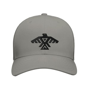 Może przedstawiać: Szara czapka typu trucker z czarną grafiką stylizowanego ptaka. Wzór ptaka jest wyśrodkowany na przodzie. Czapka ma siatkowy tył i zakrzywiony daszek.
