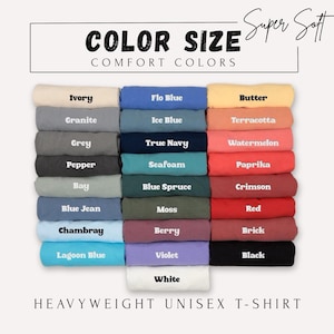 May include: A selection of folded heavyweight unisex t-shirts in a range of colours, such as Ivory, Flo Blue, and Butter. The image includes the text "COLOR SIZE COMFORT COLORS" and "Super Soft."