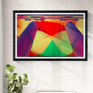 May include: A framed abstract art print featuring colorful geometric shapes and two purple columns. The artwork hangs above a white cabinet with a small plant and a black chair. A second framed piece sits on the cabinet.