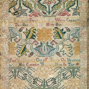 Puede incluir: Un muestrario rectangular con intrincado bordado de punto de cruz sobre tela clara. Muestra motivos florales en rojo, verde, azul y amarillo, junto con líneas de texto que incluyen la fecha 1721 y varias frases religiosas.