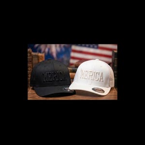 Peut inclure: Deux casquettes de baseball, une noire et une blanche, chacune avec "MERICA" brodé sur le devant. La casquette noire a un dos en filet. La casquette blanche a une visière incurvée. Les casquettes sont exposées sur une surface en bois, avec un drapeau américain flou en arrière-plan.