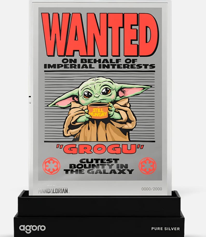 May include: A silver-framed poster featuring Grogu from The Mandalorian, holding a mug that says "Still Hungry." The poster reads "WANTED" in red, with text below. The bottom reads "Grogu, Cutest Bounty in the Galaxy."