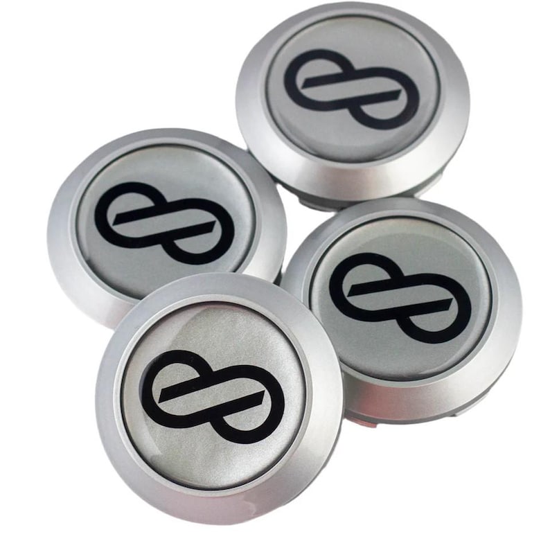 May include: Four silver wheel center caps with a black infinity symbol logo in the center.