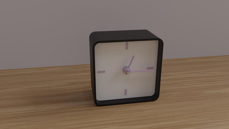 May include: A black square analog clock with a white face, featuring purple hands and hour markers. The clock sits on a wooden surface. The clock's dimensions are approximately 4 inches by 4 inches.