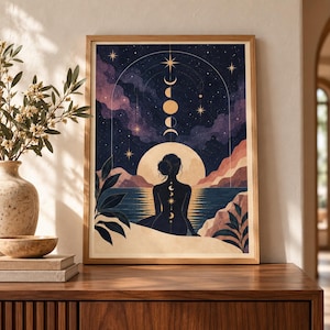 May include: A framed wall art print featuring a silhouette of a person sitting by a body of water at night. The scene includes a large moon, a starry sky with a moon phase cycle, and mountains. The person has a vertical row of moon phases on their back.