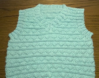 Handknit blue baby vest in washable merino wool