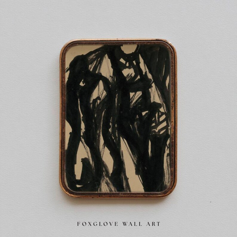 May include: Rectangular wall art with a gold-colored frame. The artwork features black brushstrokes on a beige background. The text "FOXGLOVE WALL ART" is printed in a serif font at the bottom of the image.