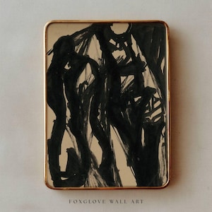 May include: Abstract art print in a rectangular gold frame. The artwork features bold black brushstrokes on a beige background. The text "FOXGLOVE WALL ART" is printed at the bottom of the frame.