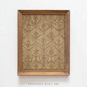May include: A framed piece of wall art featuring a repeating pattern of dark brown floral motifs on a tan background. The artwork is enclosed in a rectangular, light brown wooden frame. The text "FOXGLOVE WALL ART" is at the bottom.