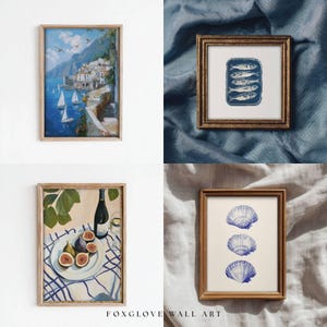 May include: Four framed art prints. One depicts a coastal scene with white buildings, blue water, and sailboats. Another shows sardines in a can. A third features figs, a bottle of wine, and a glass. The last print displays three blue seashells.