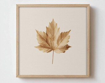 May include: A square framed wall art piece featuring a single, detailed brown maple leaf centered on a light beige background. The frame is made of light-colored wood. The text "FOXGLOVE WALL ART" is printed in black at the bottom center.