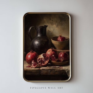 以下が含まれることがあります： ザクロ、暗いピッチャー、木製のボウルを描いた額入りの静物画。ザクロは深い赤色で、種を明らかにするために1つがカットされています。絵画はヴィンテージの美学を持っています。