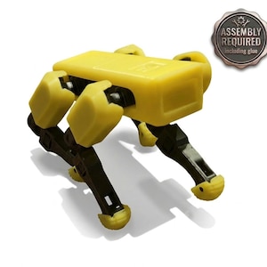 May include: A yellow and black robotic toy in the shape of a quadruped. The toy has a rectangular body and articulated legs. The image includes a badge that says "ASSEMBLY REQUIRED including glue".