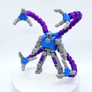 May include: A multi-jointed robot toy with a blue chest, gray limbs, and purple tentacles. The toy has articulated joints and three-pronged grippers at the end of each tentacle. The toy is posed on a white surface.