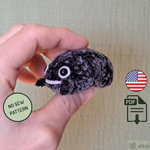 May include: A small, plush, dark gray creature with a white mouth and large, round, white-rimmed eyes. The text "NO SEW PATTERN" is on a green circle. An American flag and a PDF download icon are also visible.