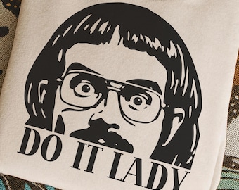 Può includere: Una felpa beige con una grafica nera di un uomo con occhiali e baffi. Il testo "DO IT LADY" è stampato sotto la grafica. La parte inferiore dell'immagine include il testo "PNG HIGH QUALITY IMAGE - EASY USE SVG".