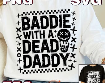 Può includere: Felpa bianca con la scritta "BADDIE WITH A DEAD DADDY" in grassetto nero. Il design include un teschio con gli occhi a croce e una mano che fa il gesto del rock and roll. La felpa ha anche il testo "PNG", "SVG" e "EPS".