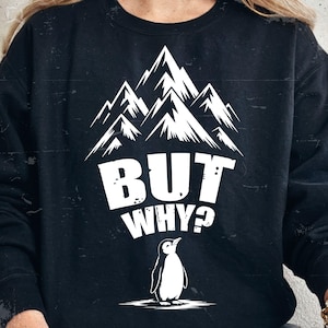 Peut inclure: Sweat-shirt noir avec un motif blanc de sommets montagneux, le texte "BUT WHY ?" et une illustration de pingouin. Le motif est centré sur le devant du vêtement.