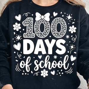 Peut inclure: Sweat-shirt noir avec texte et graphiques blancs célébrant 100 jours d'école. Le motif comprend le chiffre "100" avec un motif léopard, un nœud, des cœurs, des étoiles et des fleurs.