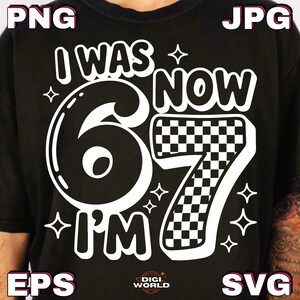 Pode incluir: Camiseta preta com uma estampa branca que diz "I WAS 6 NOW I'M 7". O n&uacute;mero 6 &eacute; grande e contornado, o 7 tem um padr&atilde;o quadriculado. Pequenas estrelas circundam o texto.