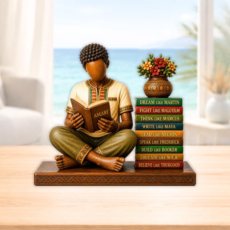 Puede incluir: Una figura de madera de una persona leyendo un libro con la etiqueta "AMARI", sentada con las piernas cruzadas. Junto a la figura hay una pila de libros con citas inspiradoras. Un jarr&oacute;n con flores se encuentra encima de los libros. La figura est&aacute; sobre una base de madera.