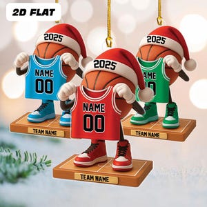 May include: Three basketball-shaped ornaments wearing Santa hats with "2025" on them. Each ornament holds a jersey with "NAME" and "00" on it. The jerseys are blue, red, and green. Each ornament stands on a wooden base with "TEAM NAME" on it.