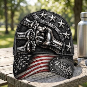 May include: Black baseball cap with an American flag design on the brim. The cap features metallic fist graphics with the names Olivia, Mason, Ethan, and Daddy. The words "Best Dad Ever" are on the side.