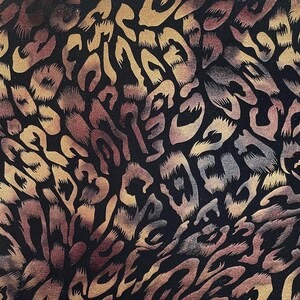 May include: Abstract pattern fabric with a black background and a brown and gold animal print design.