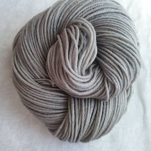 May include: A skein of light gray yarn, wound into a ball shape.