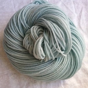 Moonstone, a light blue solid with pale gray and green tones, hand dyed yarn, worsted, indie dyer