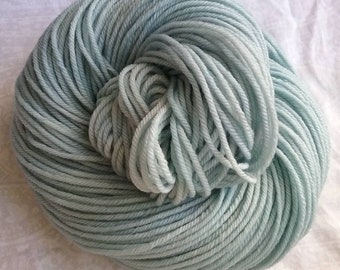 Moonstone, a light blue solid with pale gray and green tones, hand dyed yarn, worsted, indie dyer