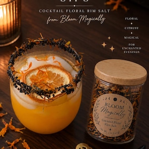 May include: A glass jar of Bloom Magically Cocktail Floral Rim Salt with a wooden lid, net weight 5 oz (142 g). The label features moon phases and text. Beside it, a cocktail glass has a black salt rim, a dried orange slice, and orange liquid.
